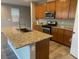 Well-equipped kitchen with granite countertops, island with sink, and stainless steel appliances at , Las Vegas, NV 89148