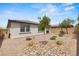 Spacious backyard with gravel landscaping, patio furniture, and a low brick wall at 10127 Knotty Skye Ave, Las Vegas, NV 89166