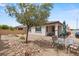 Spacious backyard featuring gravel landscaping, patio furniture, and a young shade tree at 10127 Knotty Skye Ave, Las Vegas, NV 89166