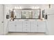 Bathroom featuring dual sinks, a large mirror, and a white vanity with drawers and cabinets at 10127 Knotty Skye Ave, Las Vegas, NV 89166