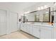 Bathroom featuring dual sinks, a large mirror, and a white vanity with drawers and cabinets at 10127 Knotty Skye Ave, Las Vegas, NV 89166