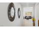 Hallway featuring decorative mirrors and tile flooring with a view into the bright living room at 10127 Knotty Skye Ave, Las Vegas, NV 89166
