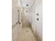 Accessible shower with beige stone-look tile, grab bars, and a glass door at 10127 Knotty Skye Ave, Las Vegas, NV 89166