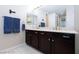 This bathroom features a double sink vanity with dark wood cabinets and granite countertop at 10356 Addie De Mar Ln, Las Vegas, NV 89135