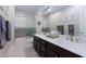 Bathroom features a double sink vanity, framed mirrors, and combined tub and shower with tile surround at 10356 Addie De Mar Ln, Las Vegas, NV 89135