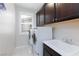 Bright laundry room features a modern washer and dryer next to white sink basin at 10356 Addie De Mar Ln, Las Vegas, NV 89135