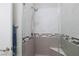 Glass enclosed shower with gray and white tiles, seat, and modern shower head at 10356 Addie De Mar Ln, Las Vegas, NV 89135