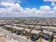 An aerial view shows a vast housing development under a sunny sky with distant mountain views at 10415 Sadie Blake Ave, Las Vegas, NV 89166