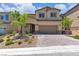 Inviting two-story home with a well-manicured front yard and a charming brick driveway at 10415 Sadie Blake Ave, Las Vegas, NV 89166