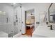 Bathroom with a white tile shower, vanity, and view to an adjacent bedroom with a ceiling fan at 10520 Maystar Ln, Las Vegas, NV 89135