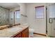 Tiled bathroom with walk-in shower, modern vanity, and granite counters at 10520 Maystar Ln, Las Vegas, NV 89135