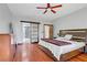 Spacious bedroom featuring hardwood floors, a ceiling fan, and a barn-style door to the bathroom at 10520 Maystar Ln, Las Vegas, NV 89135