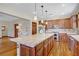 Spacious kitchen with stainless appliances, granite counters, pendant lighting, and warm wood floors at 10520 Maystar Ln, Las Vegas, NV 89135