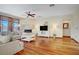 Open living room with a fireplace, tile accent wall, and hardwood floors at 10520 Maystar Ln, Las Vegas, NV 89135
