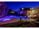 Night view of the pool and spa with custom chairs, landscaping, and lighting at 10520 Maystar Ln, Las Vegas, NV 89135