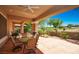 Covered back porch featuring an outdoor dining table, BBQ grill, and golf course views at 10573 Bambola Pl, Las Vegas, NV 89135