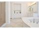 Bright bathroom featuring a soaking tub, tile floor, and built in storage cabinets at 10573 Bambola Pl, Las Vegas, NV 89135