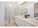Bright bathroom featuring a glass enclosed shower, dual sinks and white cabinets at 10573 Bambola Pl, Las Vegas, NV 89135