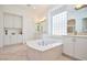 Large Primary bathroom features a deep soaking tub, dual sinks, custom lighting, and tile floors at 10573 Bambola Pl, Las Vegas, NV 89135