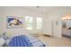 Bright bedroom with two windows, white wood floors, white armoire, and ensuite bath at 10573 Bambola Pl, Las Vegas, NV 89135