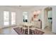 A dining area with neutral decor showcasing views and access to the outdoor space through elegant French doors at 10573 Bambola Pl, Las Vegas, NV 89135