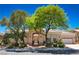 Charming single-story home featuring mature landscaping and a welcoming front entrance with a beautiful arched entryway at 10573 Bambola Pl, Las Vegas, NV 89135