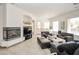Spacious living area with a fireplace, comfortable seating, and large windows providing natural light at 10573 Bambola Pl, Las Vegas, NV 89135