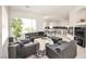 Open-concept living area with tile floors, neutral walls, a fireplace, and a view of the kitchen area at 10573 Bambola Pl, Las Vegas, NV 89135