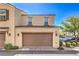 Exterior shot of a two-story townhome features a two-car garage with desert landscaping at 1201 Seaboard Ct, Henderson, NV 89002
