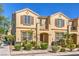 Inviting townhouse featuring stucco exterior, landscaped yard, and charming architectural details at 1201 Seaboard Ct, Henderson, NV 89002