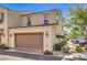 Inviting townhome exterior with a two-car garage, desert landscaping, and a convenient parking space at 1201 Seaboard Ct, Henderson, NV 89002