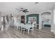 Open-concept dining room with white chairs and table that connect the living area to the kitchen at 140 Rolling Cove Ave, Henderson, NV 89011