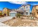 Charming two-story home with a two-car garage and desert landscaping with a beautiful, natural rock feature at 140 Rolling Cove Ave, Henderson, NV 89011