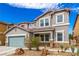 Charming two-story home with a two-car garage and desert landscaping with a beautiful, natural rock feature at 140 Rolling Cove Ave, Henderson, NV 89011