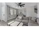 Spacious living room featuring a large sectional sofa, ceiling fan, neutral tones, and wood-look floors at 140 Rolling Cove Ave, Henderson, NV 89011