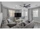 Spacious living room featuring a large sectional sofa, ceiling fan, neutral tones, and wood-look floors at 140 Rolling Cove Ave, Henderson, NV 89011