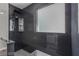 Modern shower with sleek black tiling, rainfall showerhead, and built-in niche provides a spa-like experience at 140 Rolling Cove Ave, Henderson, NV 89011