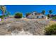 Backyard view of home with desert landscaping in need of landscape upgrade at 1420 Logandale Dr, Logandale, NV 89021
