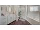 Bright bathroom featuring a soaking tub, a glass-enclosed shower, and vanity with ample counter space at 1420 Logandale Dr, Logandale, NV 89021