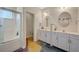 Bathroom with a tiled shower, a double vanity, and ample lighting fixtures at 1420 Logandale Dr, Logandale, NV 89021