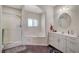 Well-lit bathroom with a glass-enclosed shower, a soaking tub, and double sinks for convenience at 1420 Logandale Dr, Logandale, NV 89021