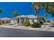 Well-maintained single-story home with a spacious front yard featuring desert landscaping and mature trees at 1420 Logandale Dr, Logandale, NV 89021