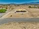 Aerial view of a new construction home with surrounding landscape and mountain views with blue skies at 1550 W Jornada St, Pahrump, NV 89048