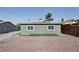 The backyard of the house is graveled with a fenced yard and view of the rear of the house at 1844 Yale St, North Las Vegas, NV 89030