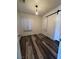 Bedroom featuring wood-look flooring, a large window, and a modern sliding barn door at 1844 Yale St, North Las Vegas, NV 89030