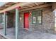 A closer exterior view of the house with a red front door and stone facade and pillars on the porch at 1844 Yale St, North Las Vegas, NV 89030