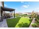 Serene backyard with artificial grass, covered patio, and charming landscaping at 212 Harris Peak St, Las Vegas, NV 89138