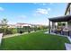 Beautiful backyard with artificial grass, patio, pergola, and manicured landscaping at 212 Harris Peak St, Las Vegas, NV 89138