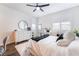 Bright bedroom features white walls, wood floors, white dresser, and makeup vanity with lighted mirror at 212 Harris Peak St, Las Vegas, NV 89138