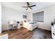 Well-lit bedroom with wood floors, white walls, a ceiling fan, and window with horizontal blinds at 212 Harris Peak St, Las Vegas, NV 89138